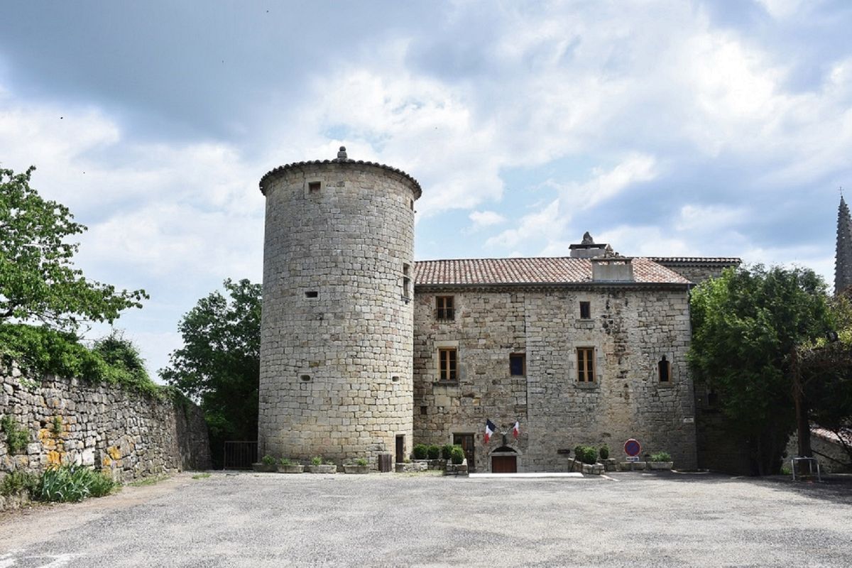 Château français avec douves et parc arboré, sous un ciel bleu
