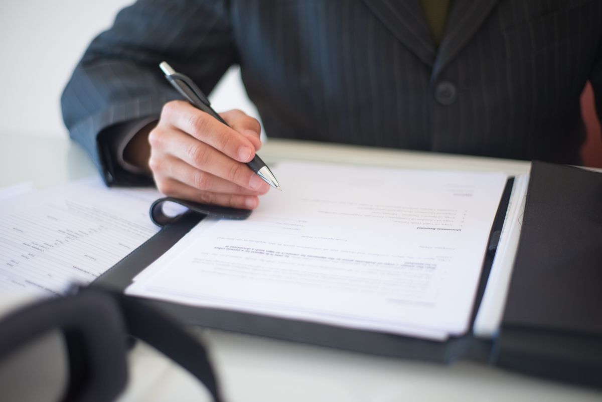 Contrat notarié signé sur un bureau avec plan cadastral
