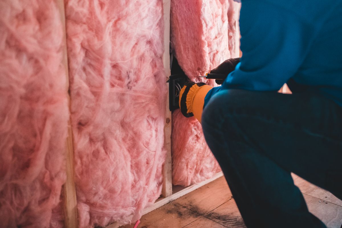 Artisan posant une isolation thermique dans les combles d'une maison ancienne